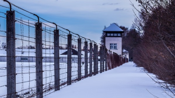 Zu sehen ist der Außenzaun und ein Wachturm des Konzentrationslagers Dachau.